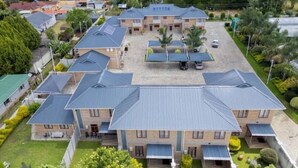 Un edificio grande de varios pisos con un patio central, rodeado de construcciones más pequeñas.