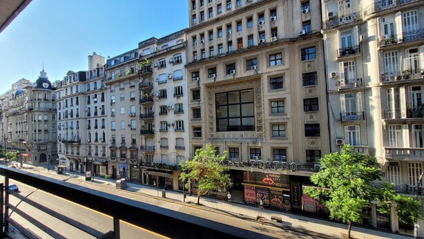 A row of multi-story buildings with balconies, a prominent theater sign, and a pedestrian walkway. - Luminoso, muy Completo y Bien Ubicado (Buenos Aires)