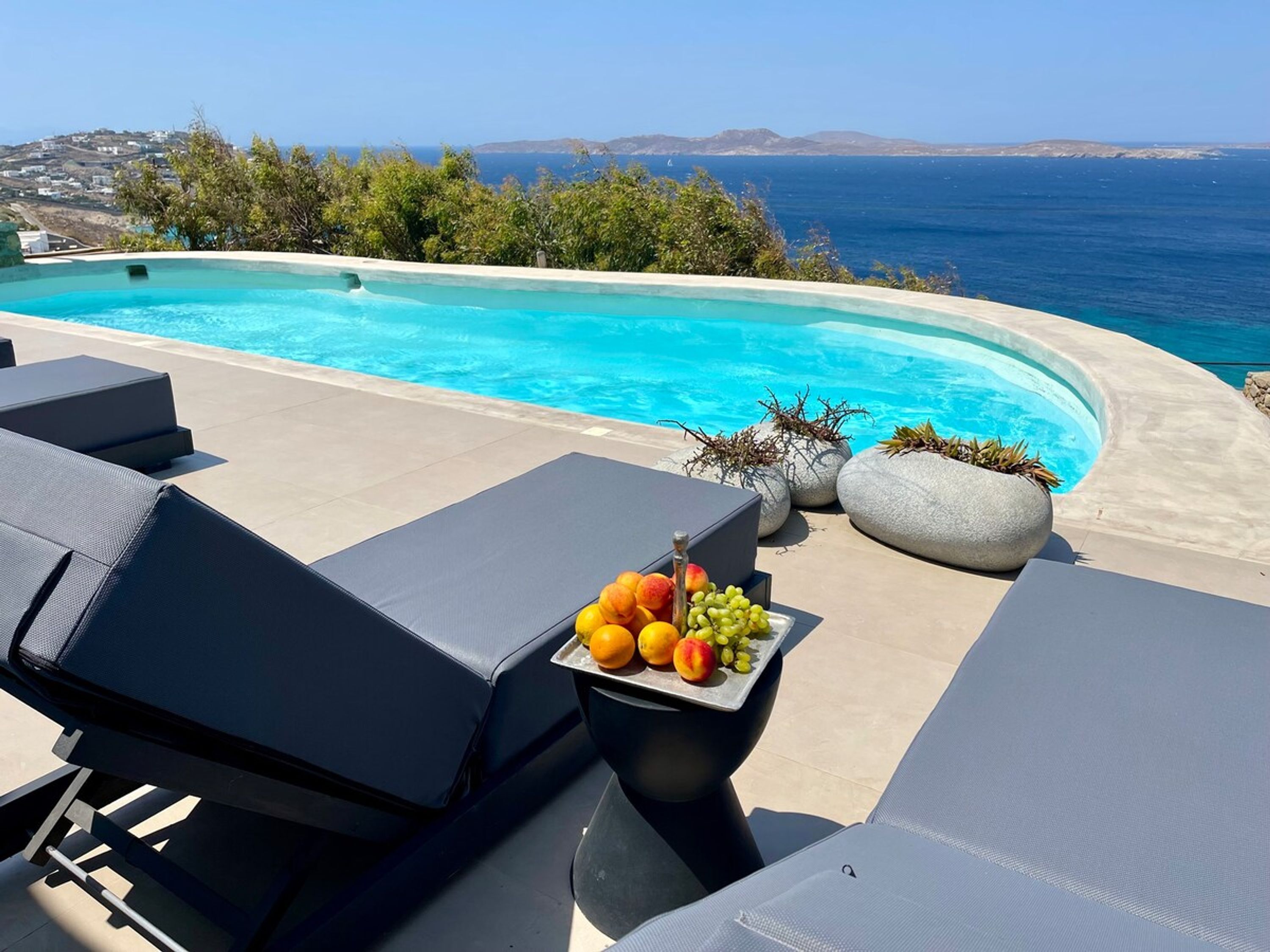 A poolside area with lounge chairs and a fruit tray.