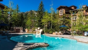 A swimming pool surrounded by wooden cabins and dense forest. - 3419b - Double Queen Standard Powderhorn Lodge Suite (Salt Lake City)