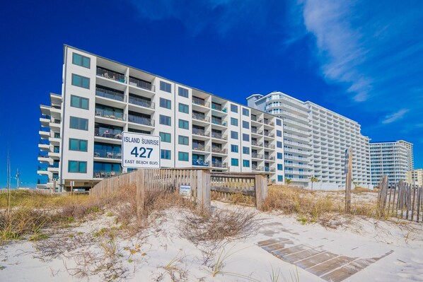Un hotel frente a la playa llamado 'Island Sunrise' con un cartel que indica la dirección '427 East Beach Blvd'.