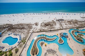 A beach resort with a large swimming pool area, a sandy beach, and a view of the ocean. - Phoenix Gulf Towers 1007 3 Bedroom Condo (Orange Beach)