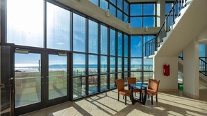 A spacious room with large floor-to-ceiling windows offering a view of the beach and ocean. - Phoenix Iii 3063 1 Bedroom Condo (Orange Beach)