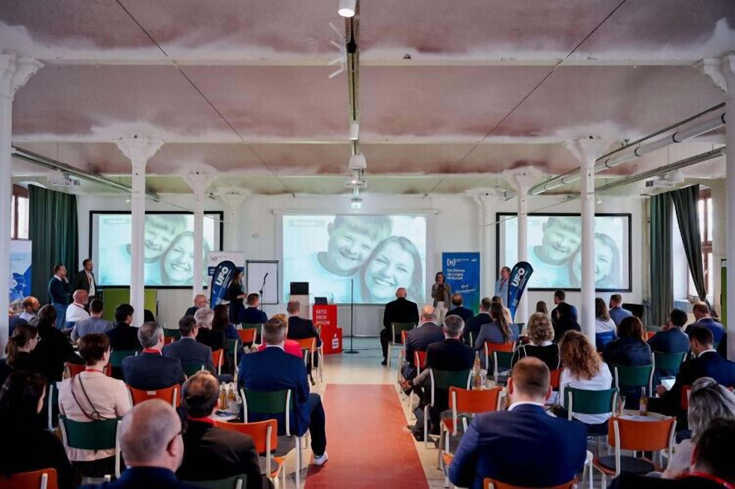 A conference room with rows of chairs facing a presentation screen.