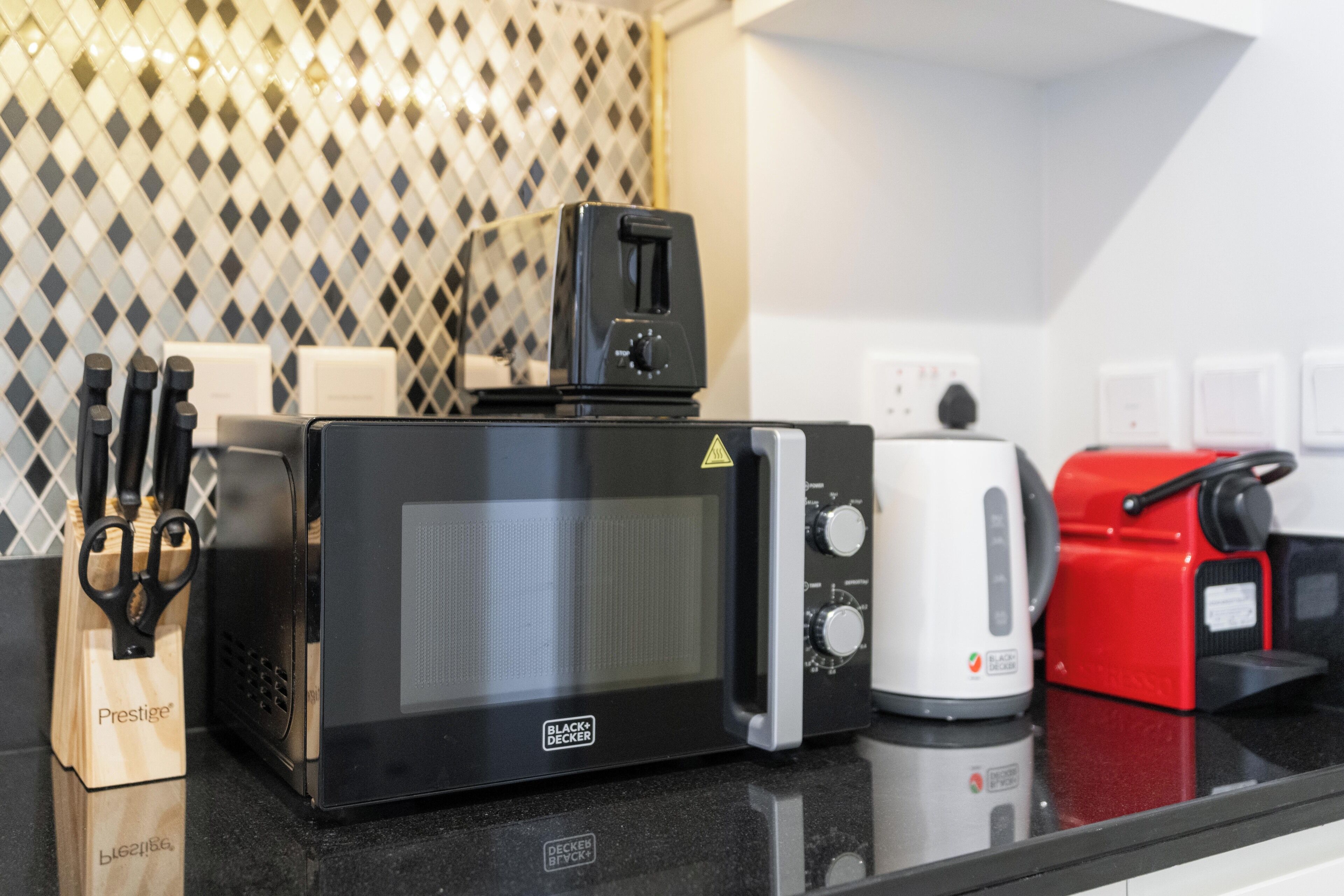Un plan de travail de cuisine avec un four à micro-ondes, un grille-pain et une machine à café.