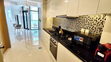 Luxury Studio Suite, City View | Private kitchen | Fridge, microwave, oven, stovetop