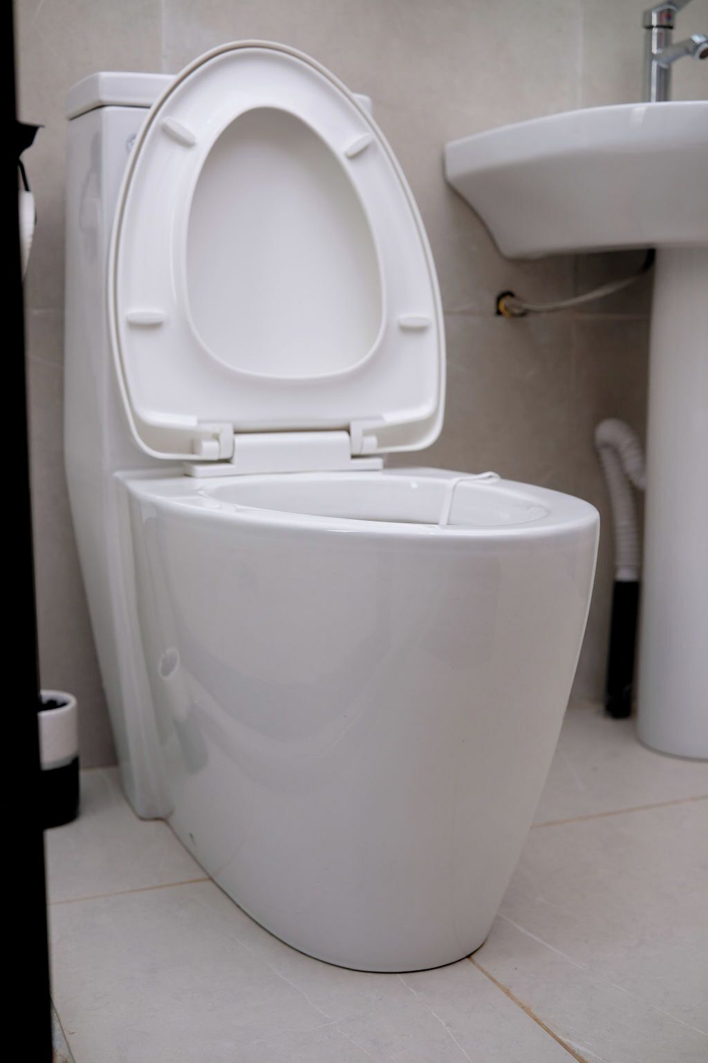 Et hvidt toilet med lukket låg i et badeværelse.