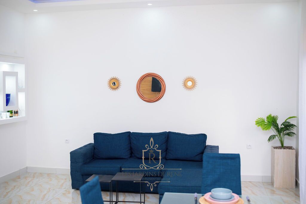 Una sala de estar moderna con un sofá azul, una mesita de centro y arte decorativo en la pared.