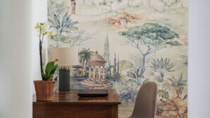 Et spiseområde med et bord, en stol, en lampe og en potteplante.