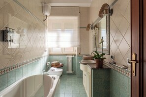 A bathroom with a bathtub, toilet, sink, and a mirror. - Incanto House - Luxury apartment near the Vatican (Roma)