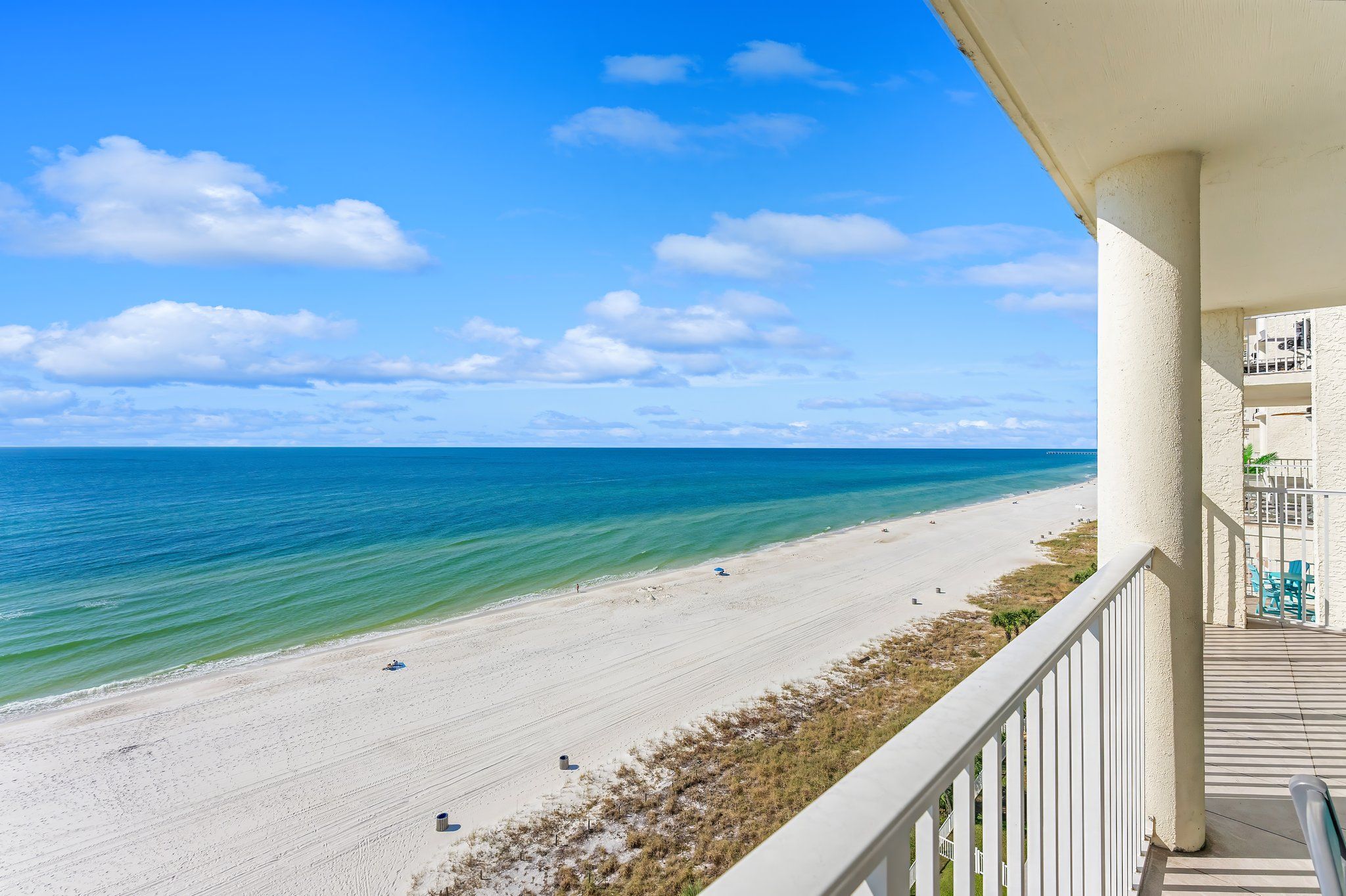 A balcony with a view of a beach and ocean.