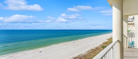 A balcony with a view of a beach and ocean.
