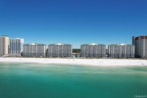 A beachfront hotel with multiple high-rise buildings, a sandy beach, and clear turquoise waters. - Free Beach Service, Golf & Perks! Long Beach III-903 Hot Tub, Gym & Pools! (Panama City Beach)