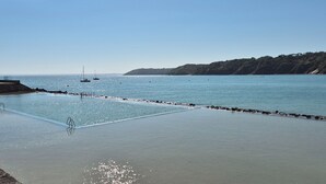 A coastal area with a swimming pool, a pier, and boats in the water. - Escapade Bretonne - Binic, beaches and old port. Large garden, high-speed wifi. (Binic-Étables-sur-Mer)