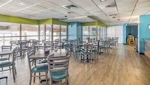 A spacious dining area with multiple tables and chairs, large windows, and a view of the outdoors. - Spectacular 3 BR 2 BA Ocean Front Condo (Myrtle Beach)
