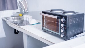 Angolo cottura con forno a incasso, lavandino e scolapiatti.