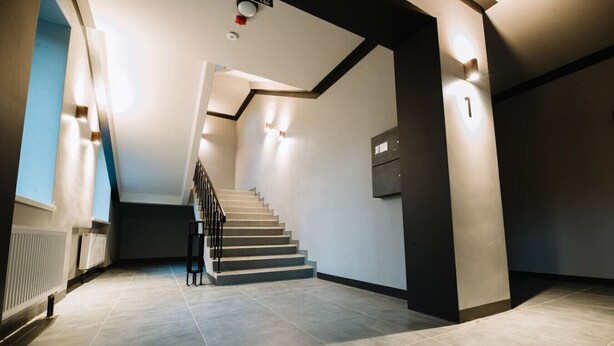 Un intérieur moderne avec un escalier, un radiateur et un meuble fixé au mur.