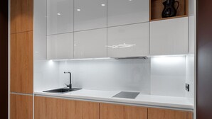 Una cocina moderna con encimera blanca, grifo negro y armarios de madera.