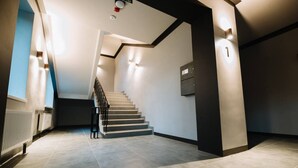 Un interior moderno con una escalera, un radiador y una lámpara fijada a la pared.