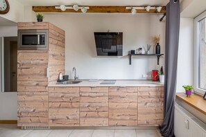 Køleskab, mikrobølgeovn, kogeplade, køkkentøj/tallerkener/redskaber