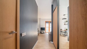 Un couloir moderne avec des portes en bois, un mur gris et un plancher en bois.