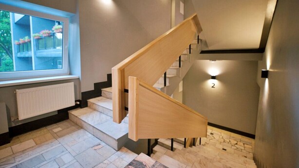 A modern staircase with wooden steps and a glass window above. - Dzintaru studio apartment (Jūrmala)