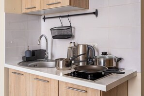 Kjøleskap, kokeplater, kjøkkenutstyr og spisebord