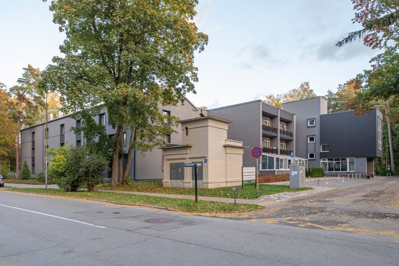A modern building with a parking area and a no parking sign.