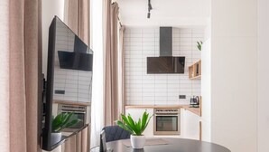 A modern kitchen with white tiles, a built-in oven, and a microwave. - Central | High-quality furniture | Studio 32 m2 (Rīga)