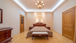 Un dormitorio con cama de madera, mesita de noche, cómoda y candelabro.