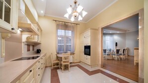 Una cocina amplia con comedor, televisor y candelabro.