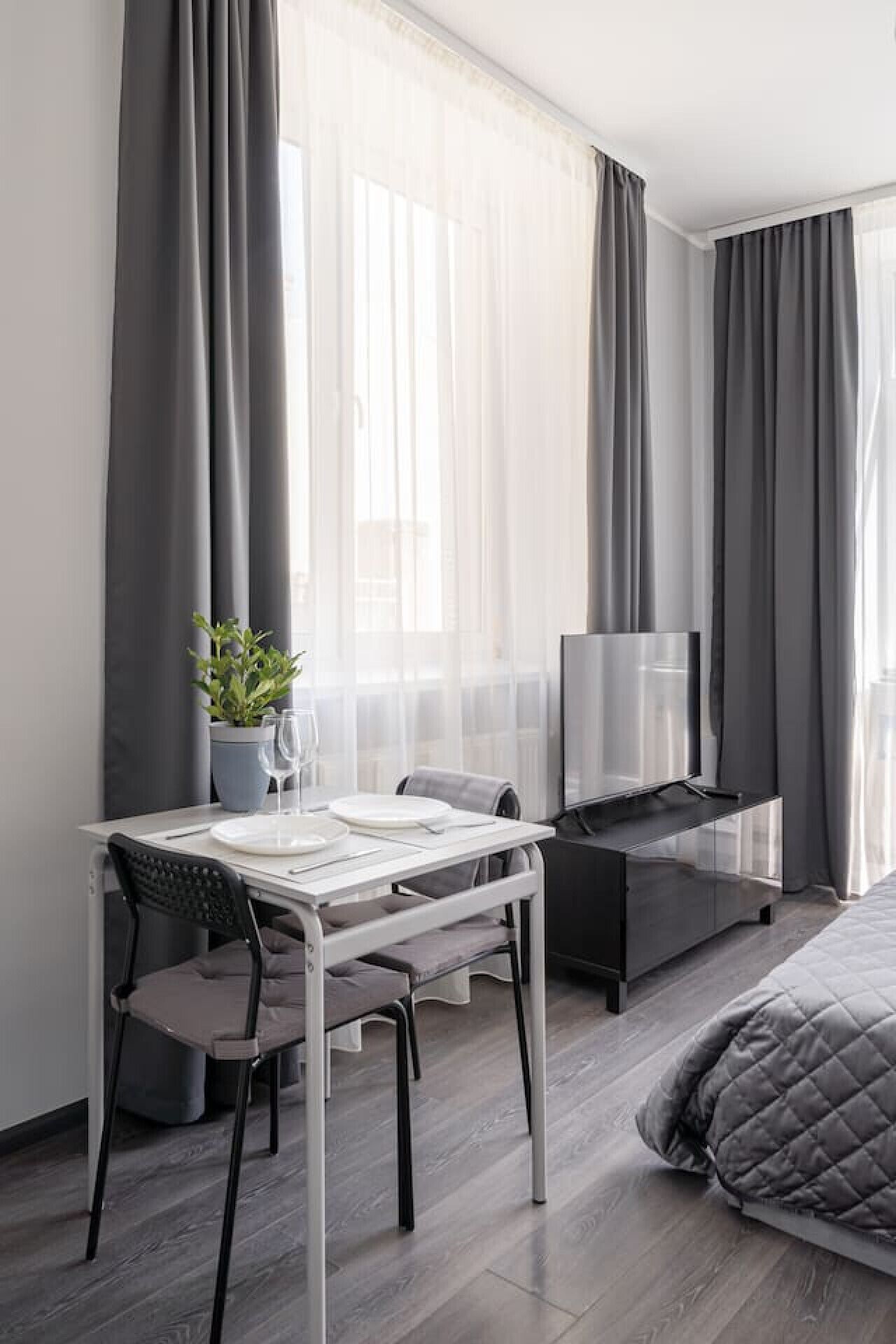 Et moderne hotelværelse med spiseplads, seng og fjernsyn.