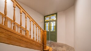 Una escala de fusta amb una porta verda i vidrieres de colors.
