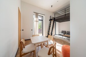 Una sala moderna con comedor, una escalera y vistas al exterior.