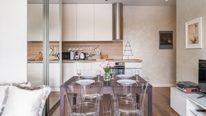 Une cuisine moderne dotée d’un espace repas, comprenant un îlot central avec des tabourets, un four à micro-ondes et une bouilloire.