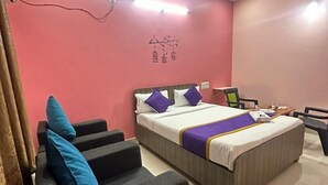 A bedroom with a bed, a desk, a chair, and a ceiling fan.