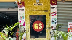 A hotel entrance with a 'Welcome' sign, a 'Golden Suites' banner, and a 'Govinda Shetty' sign.