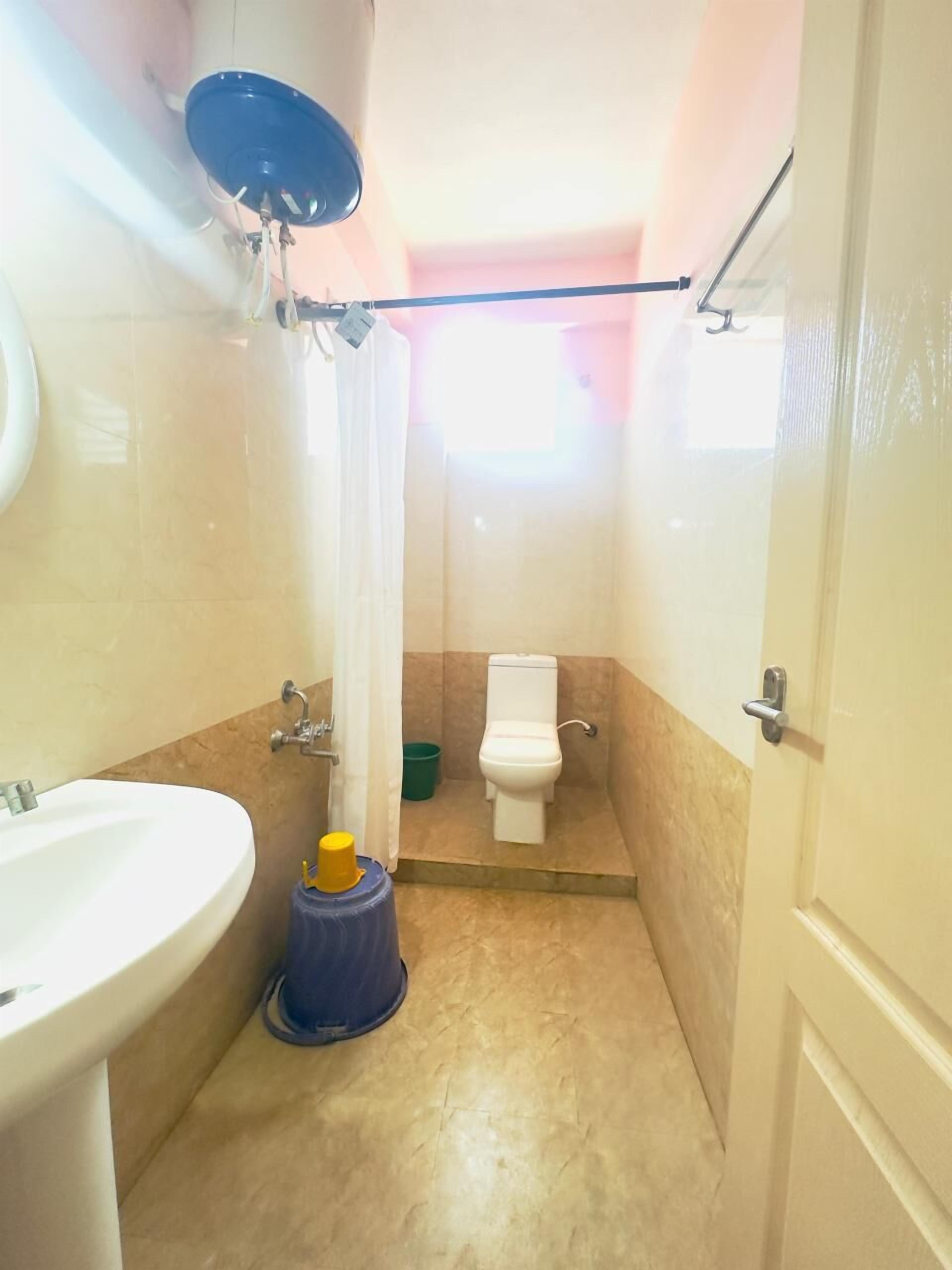 Un baño pequeño con lavamanos, inodoro y zona de ducha.