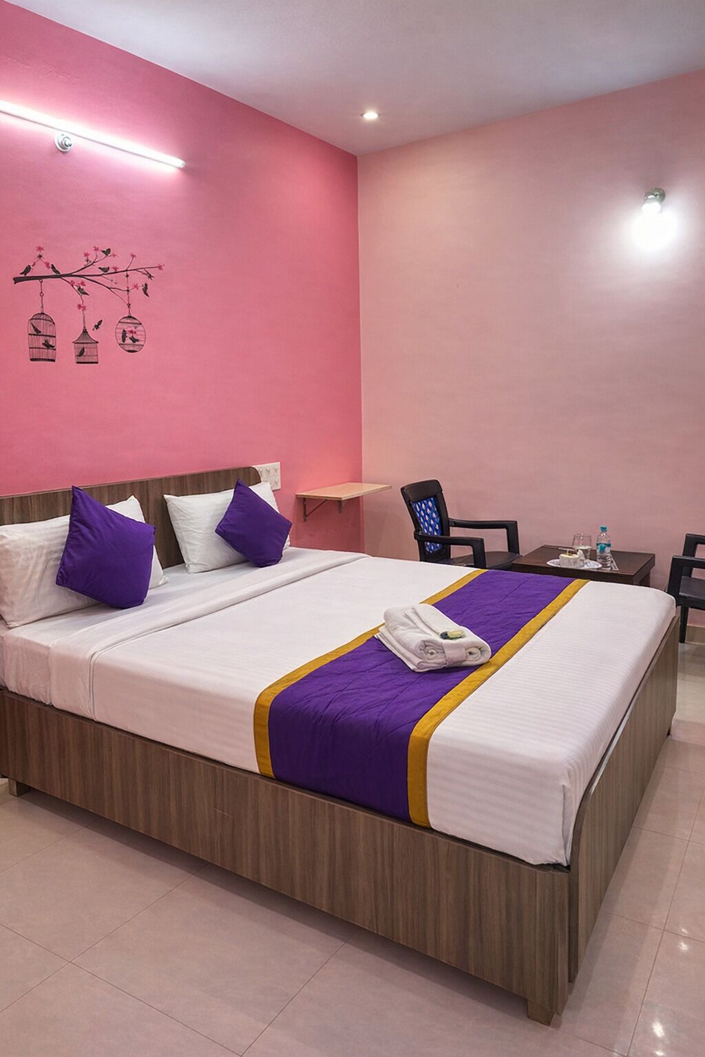 Una habitación de hotel con una cama grande, un escritorio y una silla.
