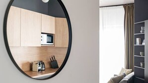 Una cocina moderna con armarios de madera, un microondas y una cafetera sobre la encimera.