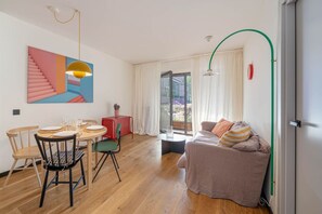 Ein modernes Wohnzimmer mit Essbereich, einer Couch und einer Treppe.