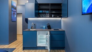 A modern kitchen with a built-in refrigerator, a sink, and a countertop. - Sojourn in Old Town studio apartment (Riga)