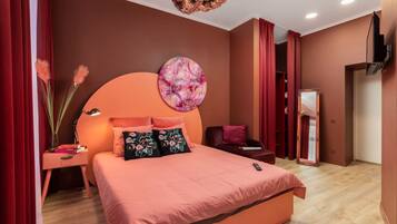 Un dormitorio con una cama grande, una mesita de noche, un televisor montado en la pared y un espejo.