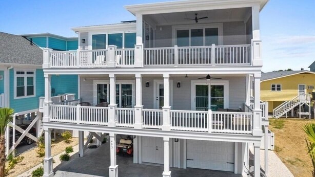 A two-story house with a balcony on the upper floor, a garage, and a driveway.