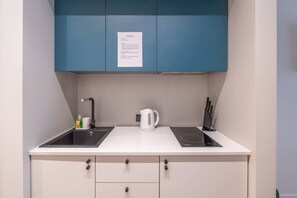 Kjøleskap, kokeplater, kjøkkenutstyr og spisebord