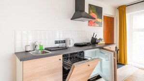 Uma cozinha compacta com lava-louças, chaleira e torradeira.