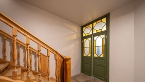 Gradi de fusta amb una porta verda i finestres de vitralls.