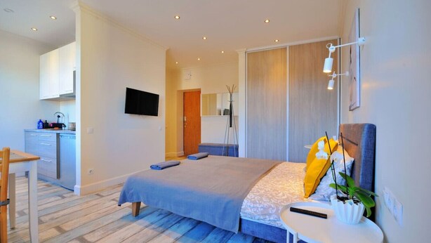 Une chambre moderne avec un lit, une table de chevet et un petit espace bureau.