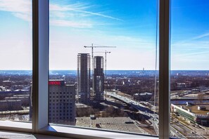 Vista de un paisaje urbano con un edificio identificado como 'UKOIL' y varias grúas de construcción.