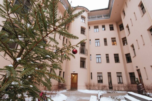 A building with multiple windows and a door, surrounded by snow.